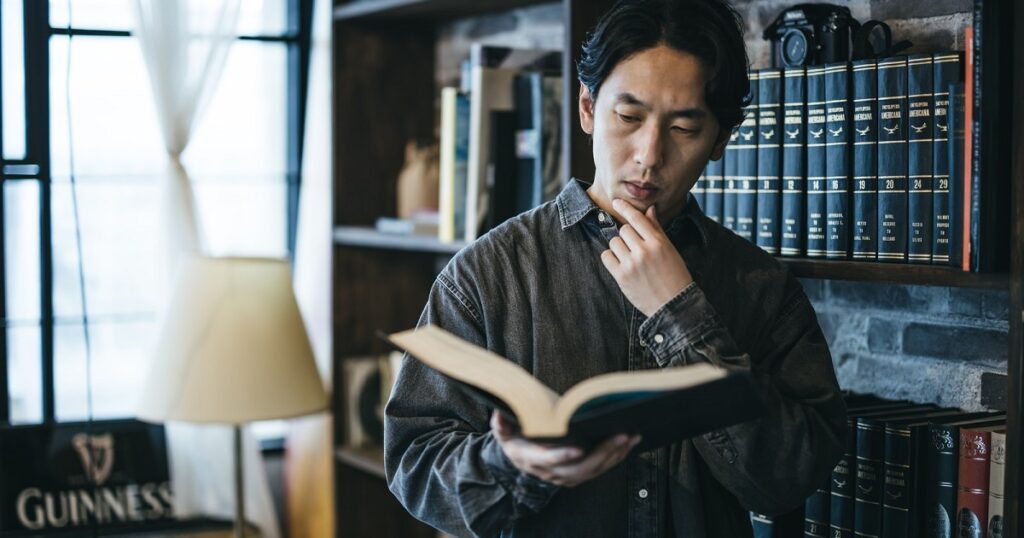 分厚い百科事典を広げる男性_1200_630