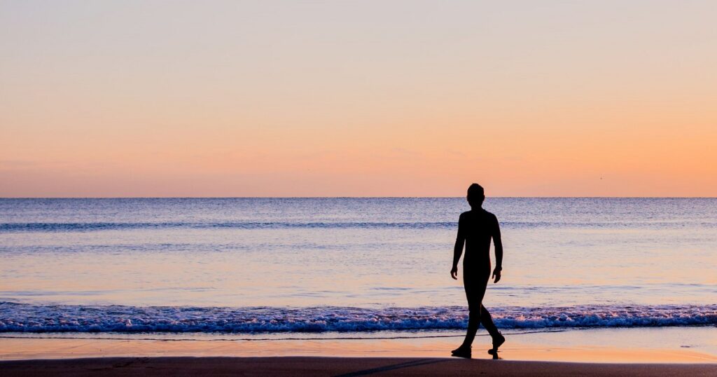 夕暮れの砂浜を歩く男性_1200_630